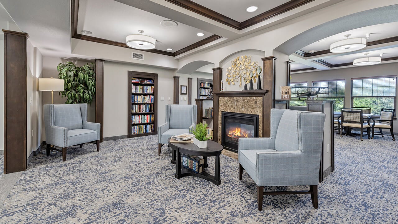The library at The Oaks with shelves of books and comfortable seating